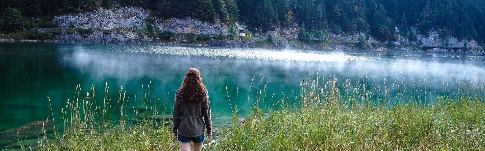 Image d'une femme de dos qui marche en nature pour illustrer que l'observation de soi permet de repérer les fonctionnements nuisibles et d'y mettre fin.