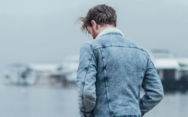 Image d'un homme seul, la tête penchée, qui a des besoins affectifs insatisfaits.